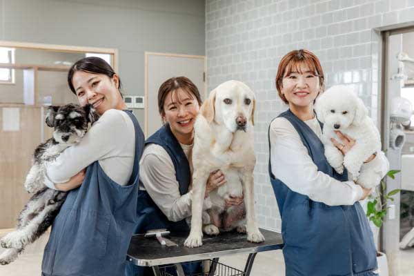 犬を支えて並ぶスタッフ